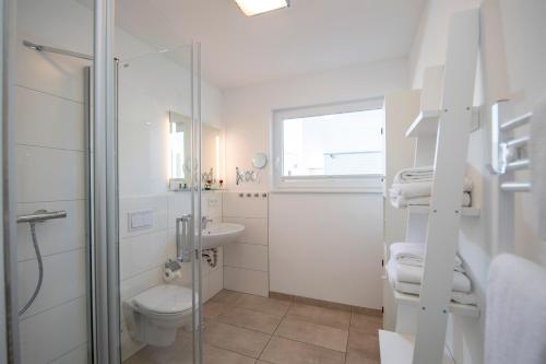 een badkamer met een douche, een toilet en een wastafel bij Schwimmendes Haus Jule in Olpenitz
