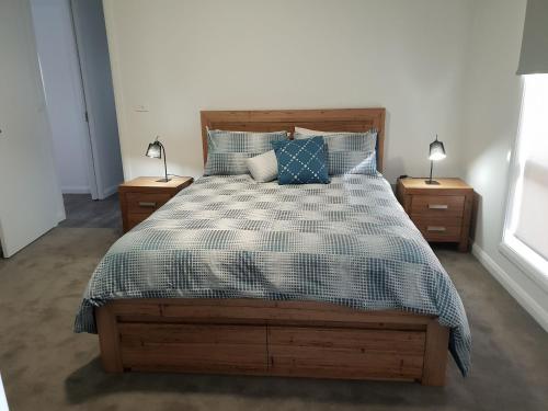 a bedroom with a bed and two night stands with lamps at 123 Wilson - Arapiles in Horsham