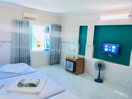 um quarto com duas camas e uma televisão na parede em Thanh Sơn Motel em Vung Tau