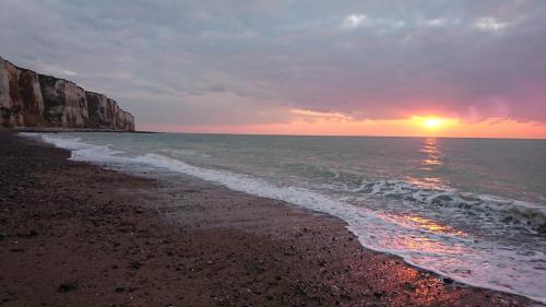 a sunset on a beach with the ocean at Gîte le tréportais in Le Tréport