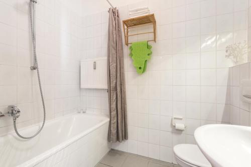 a bathroom with a tub and a toilet and a sink at Ruhiges Apartment am Rande des Szeneviertels in Dresden