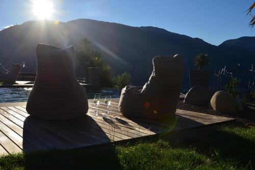 two pillows sitting on a wooden deck with the sun at Ebnerhof in Appiano sulla Strada del Vino