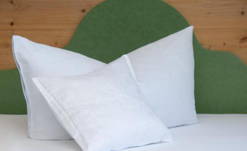 two white pillows sitting on top of a bed at Haus Arnika in Mellau