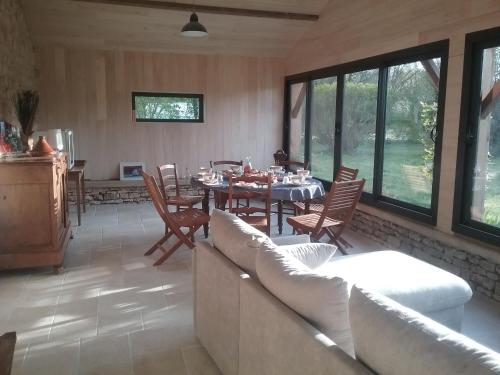 a living room with a dining table and chairs at La Maison des Escargots in Blanzay