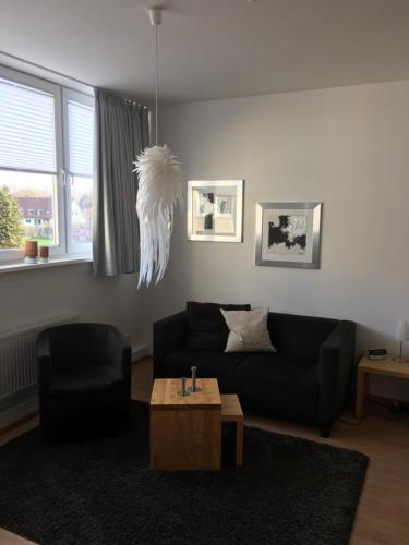 a living room with a black couch and a table at Ferienwohnung Schleswig in Schleswig