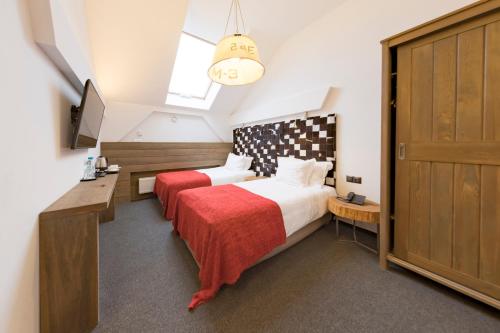 a bedroom with a bed and a desk and a tv at Hotel Jakubus in Wilków