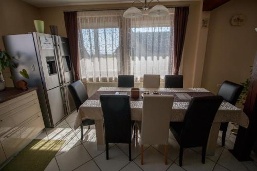 a kitchen with a table and chairs and a refrigerator at Barátkozó Vendégház in Szentantalfa