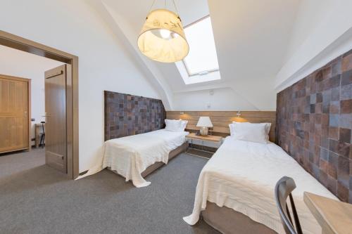 a bedroom with two beds and a skylight at Hotel Jakubus in Wilków