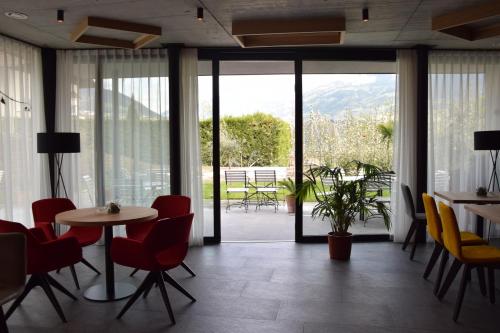 a room with a table and chairs and a large window at Garden-Suite Faselehof in Marlengo