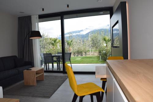 a kitchen and living room with a table and chairs at Garden-Suite Faselehof in Marlengo