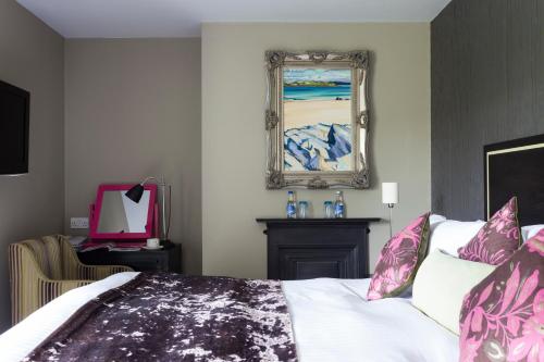 a bedroom with a bed and a painting on the wall at The Cornwall Hotel Spa & Lodges in St Austell