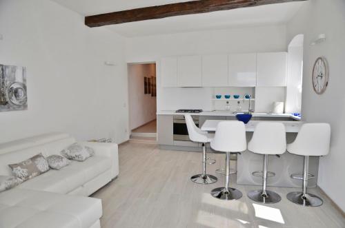 a white living room with a white couch and a kitchen at The Best View Of The Sea in Lerici