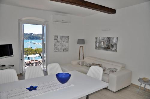 sala de estar con mesa blanca y sillas en The Best View Of The Sea, en Lerici