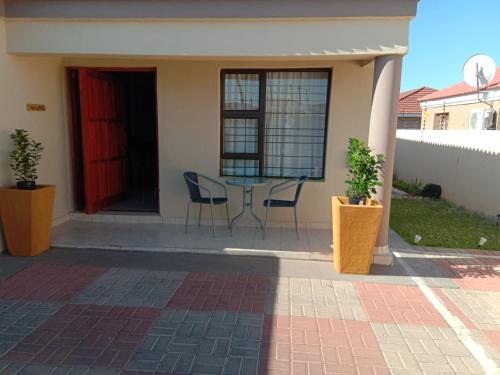 a patio with a table and chairs in front of a house at Tap's Home Away from Home in Gaborone