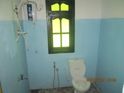 a bathroom with a toilet and a window at Tree House Holiday Home in Bandarawela
