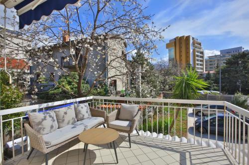Balcón con sofá, 2 sillas y mesa en Marinero Apartments, en Budva