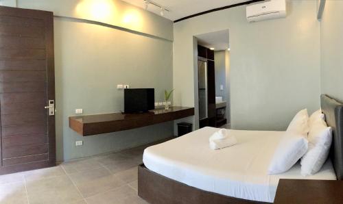 a bedroom with a bed with a television and a door at Seabird International Resort in Boracay