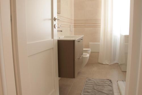 a white bathroom with a toilet and a sink at LG apartment in Stresa