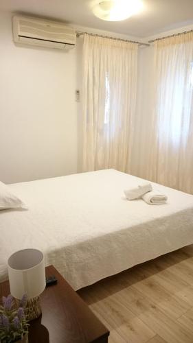 een slaapkamer met een groot wit bed en een tafel bij Agias Sofias Apartment Corfu in Corfu-stad