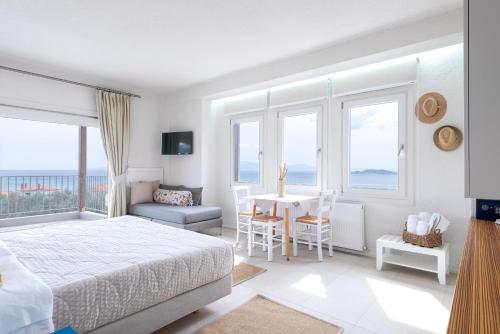 1 dormitorio con 1 cama, mesa y sillas en Villa Almira Luxury Apartments, en Ouranoupoli