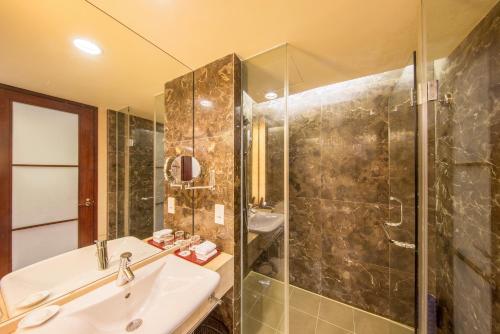 a bathroom with a sink and a shower at Dongguan Richwood Garden Hotel in Dongguan