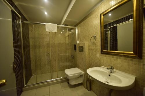 uma casa de banho com um chuveiro, um WC e um lavatório. em Hotel Topkapı em Istambul