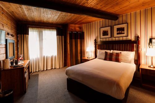 a hotel room with a large bed and a window at Chevin Country Park Hotel & Spa in Otley