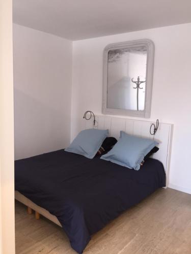 a bedroom with a bed with a mirror and a cross on the wall at Natalilocs in Golfe-Juan