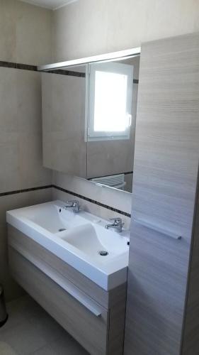 une salle de bain avec un lavabo blanc et un miroir dans l'établissement villa-castellane, à Castellane