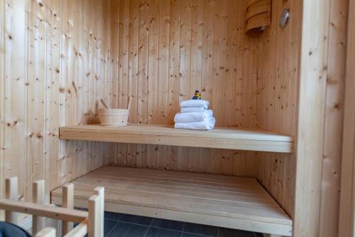 a sauna with a stack of towels on a shelf at Seaside in Olpenitz