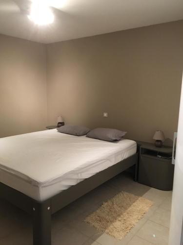 une chambre avec un grand lit avec des draps blancs dans l'établissement villa-castellane, à Castellane