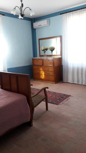 een slaapkamer met een dressoir, een bed en een spiegel bij Alloggio Cantalupo in Formigine