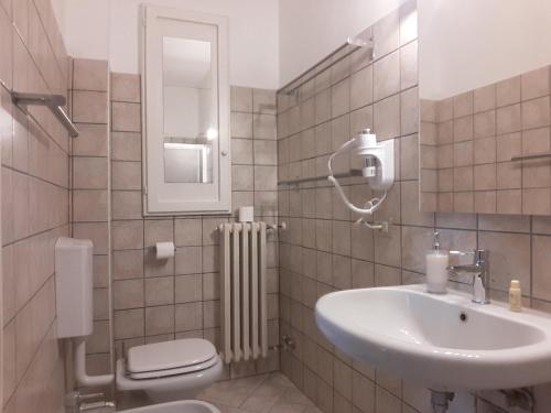 een badkamer met een wastafel, een toilet en een spiegel bij Alloggio Cantalupo in Formigine