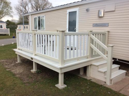 a porch on a mobile home with a white deck at Neecee’s Retreat in Tattershall