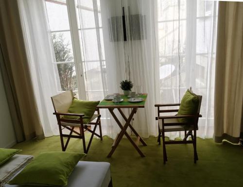 a dining room with a table and two chairs and windows at Mosel - River - Quartier 31 in Lieser