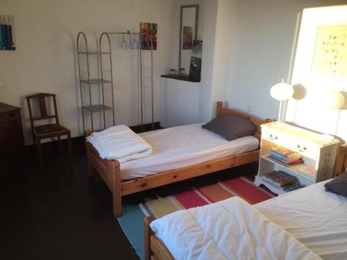 um quarto com 2 camas, uma cadeira e uma janela em Gite a la campagne em Sardent