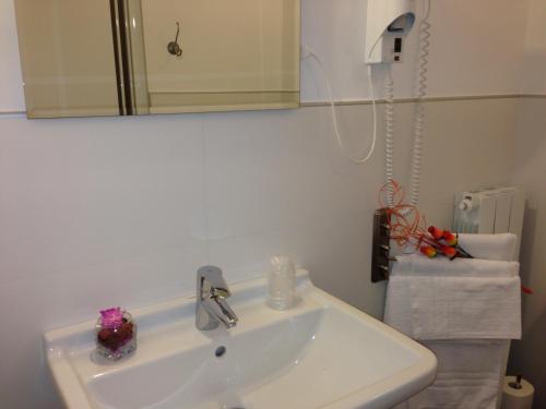 a bathroom with a sink and a mirror and towels at Hotel Adler in Foppolo
