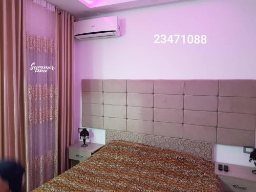 a bedroom with a bed and a sign on the wall at APPARTEMENT "DINA" Kélibia in Kelibia