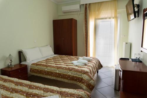 a hotel room with two beds and a couch at Pension Konstantinoupolis in Asprovalta