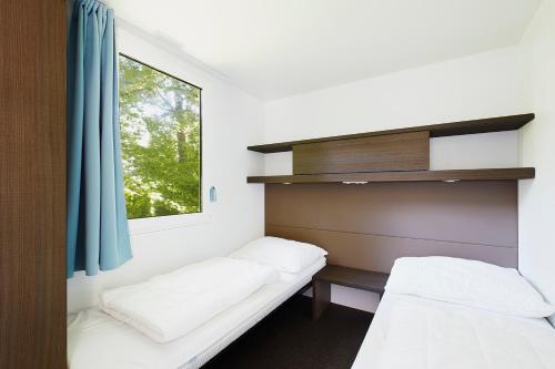 Zimmer mit 2 Betten und einem Fenster in der Unterkunft Donaupark Camping Tulln in Tulln