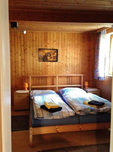 a bedroom with a bed in a wooden wall at Reiterhof Winandy in Wietzendorf