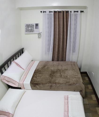 a bedroom with two beds and a window at Dignadice's Homestay in Coron
