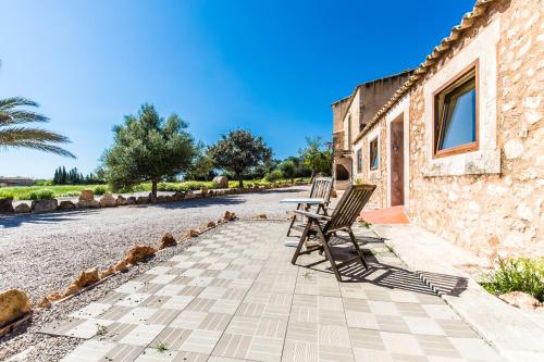 a row of chairs sitting on a patio next to a building at Finca Agroturismo Sa Cova den Borino in Campos