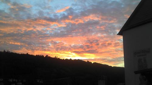 a sunset in the sky over a hill at Weingut Stiftshof in Enkirch