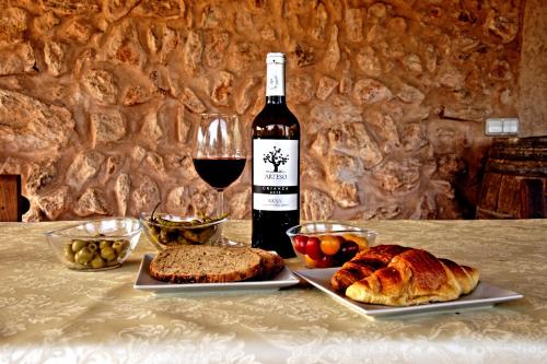 a bottle of wine and a plate of bread and a glass at Finca Agroturismo Sa Cova den Borino in Campos
