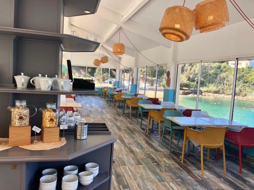 a restaurant with tables and chairs and windows at Hôtel Sampiero in Propriano