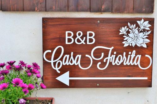 a sign on the side of a building with flowers at Casa Fiorita in Gragnano