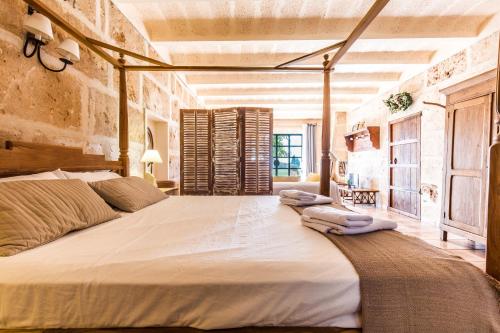 a bedroom with a large bed with towels on it at Finca Agroturismo Sa Cova den Borino in Campos