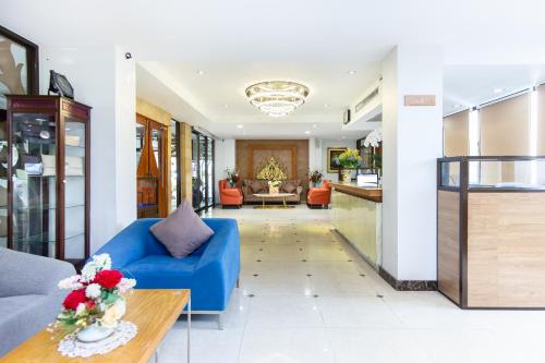 バンコクにあるLasalle Suites Hotel & Residenceのリビングルーム(青いソファ、テーブル付)