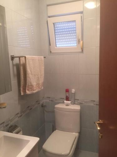 a bathroom with a toilet and a sink and a window at Apartment Ejla in Medulin